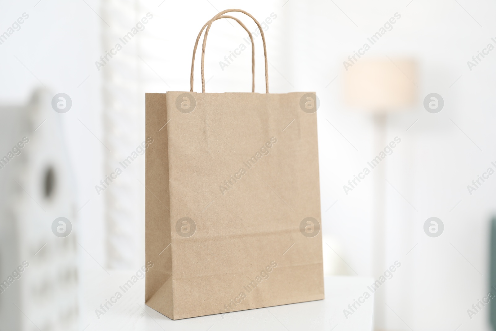 Photo of Paper bag on white shelf indoors, closeup