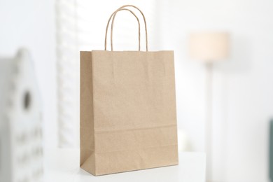 Photo of Paper bag on white shelf indoors, closeup