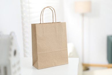 Photo of Paper bag on white shelf indoors, closeup. Space for text