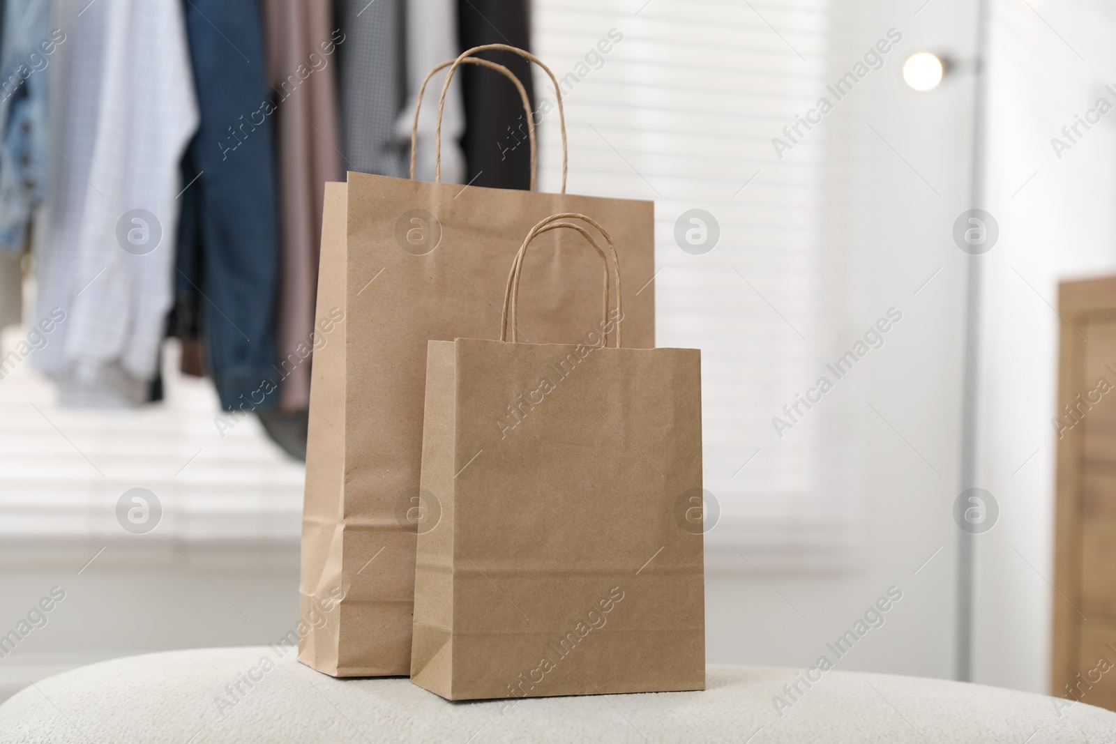 Photo of Paper bags on white pouf indoors, closeup