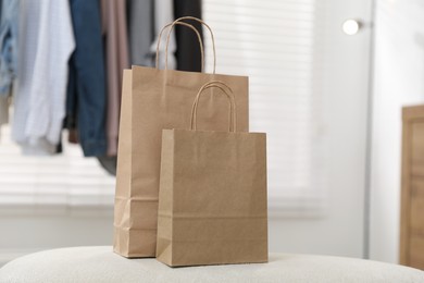 Photo of Paper bags on white pouf indoors, closeup