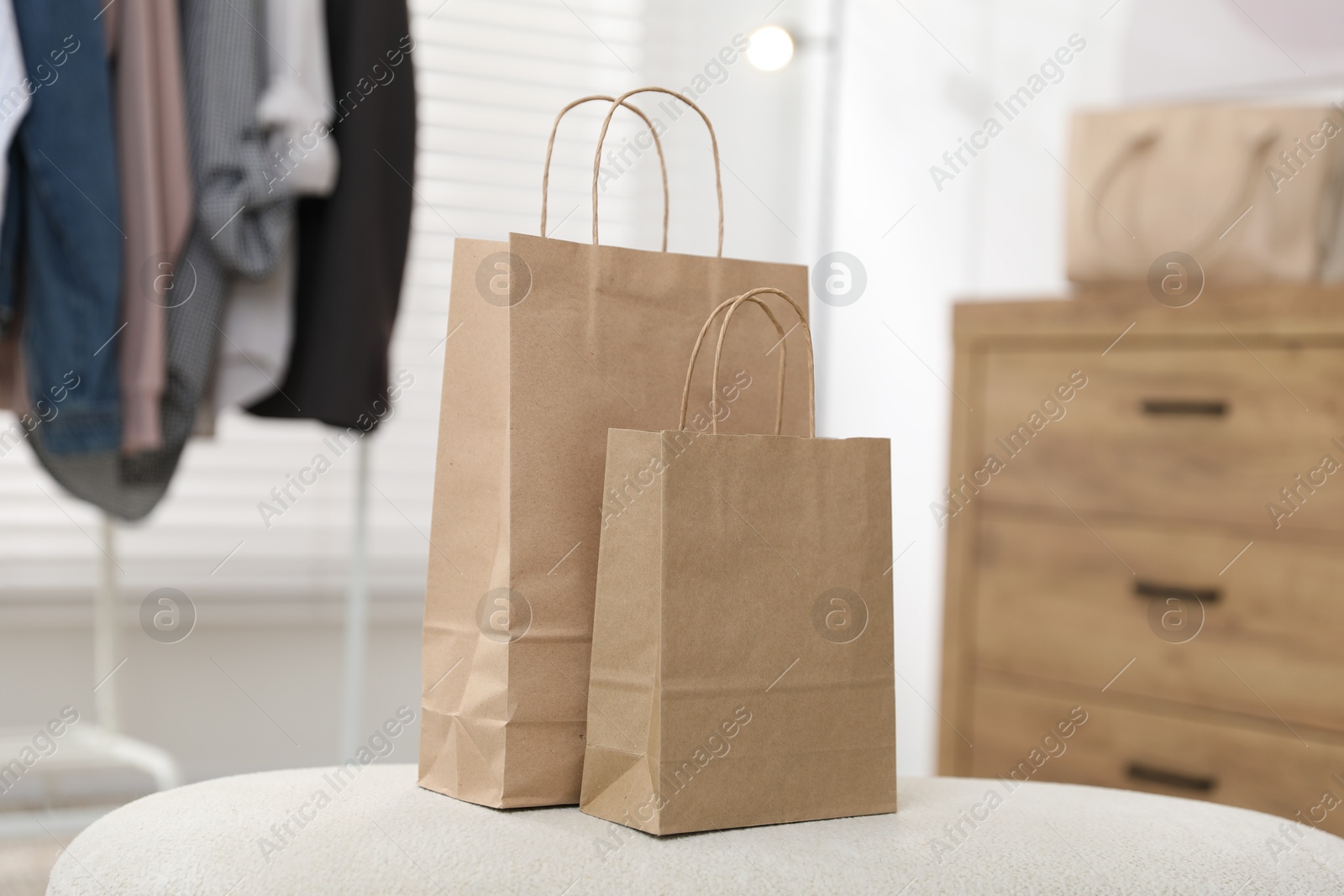 Photo of Paper bags on white pouf indoors, closeup