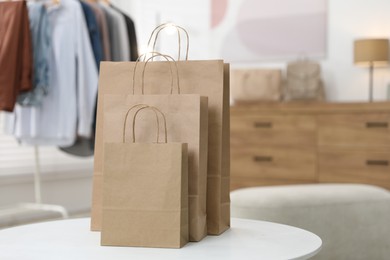 Photo of Paper bags on white table indoors, closeup. Space for text