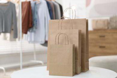 Photo of Paper bags on white table indoors, closeup. Space for text