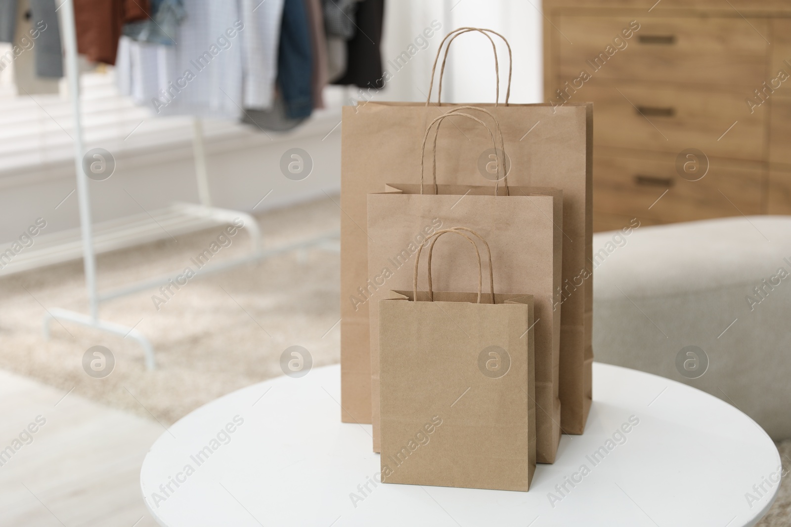 Photo of Paper bags on white table indoors, closeup. Space for text