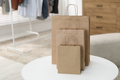 Photo of Paper bags on white table indoors, closeup. Space for text