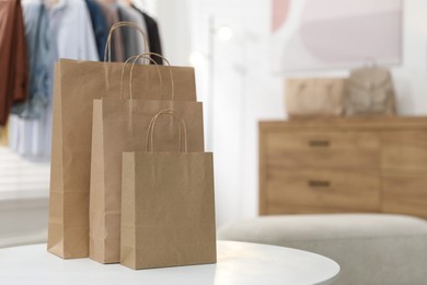 Photo of Paper bags on white table indoors, closeup. Space for text