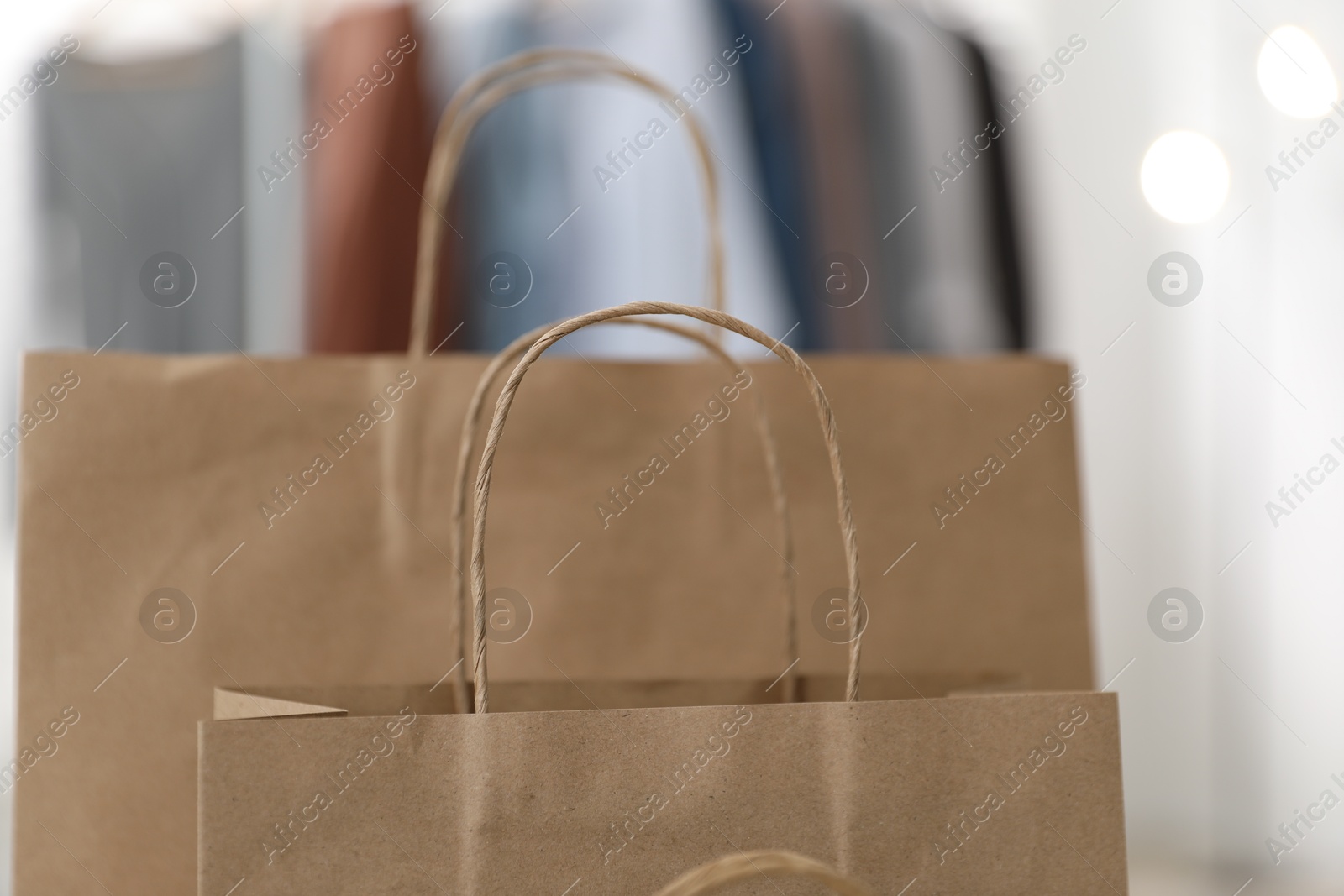 Photo of Paper bags with handles against blurred background, closeup