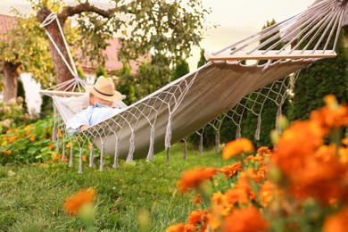 Photo of Senior woman resting in comfortable hammock outdoors