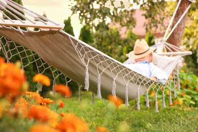 Photo of Senior woman resting in hammock outdoors, selective focus