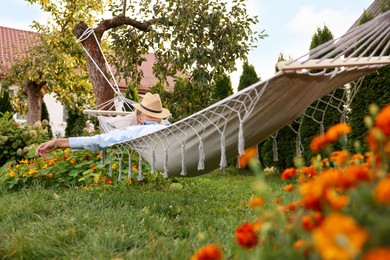 Photo of Senior woman resting in comfortable hammock outdoors