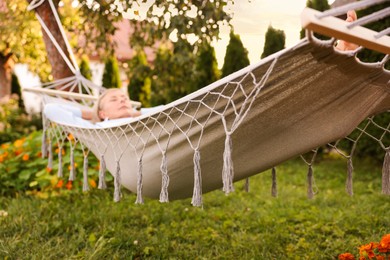 Photo of Senior woman resting in comfortable hammock outdoors