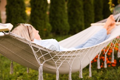 Photo of Senior woman resting in comfortable hammock outdoors