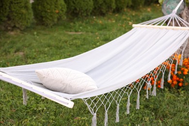 Photo of Comfortable white hammock with pillow in garden