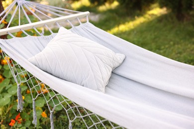 Photo of Comfortable white hammock with pillow in garden