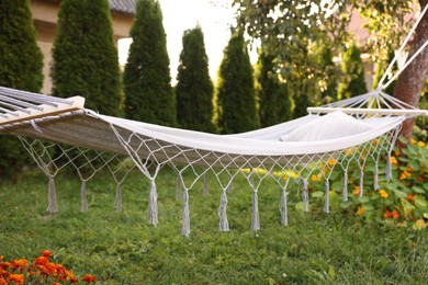 Photo of Comfortable white hammock with pillow in garden