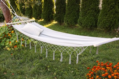 Photo of Comfortable white hammock with pillow in garden