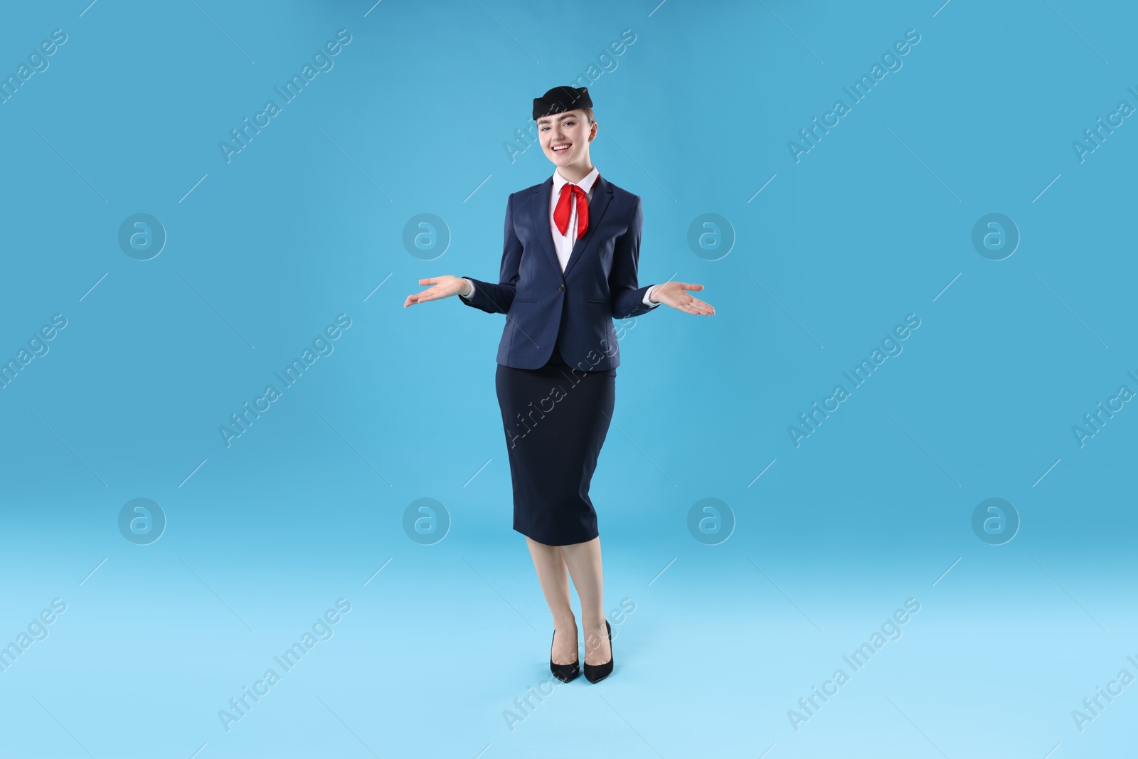 Photo of Positive stewardess doing pre-flight safety briefing on light blue background