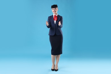 Photo of Positive stewardess doing pre-flight safety briefing on light blue background