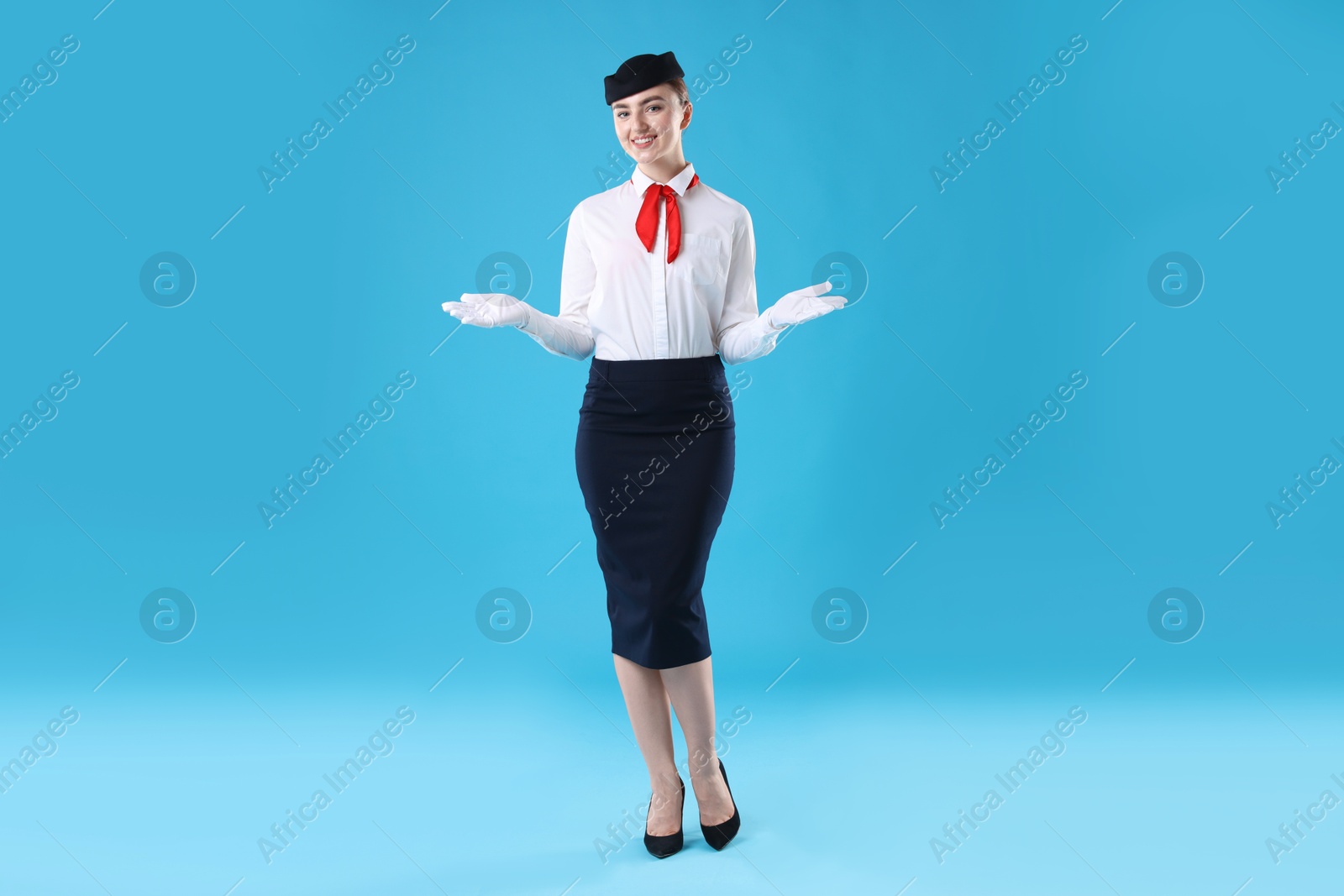 Photo of Positive stewardess doing pre-flight safety briefing on light blue background