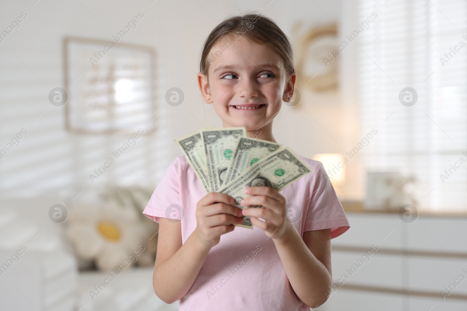Photo of Little girl holding pocket money at home