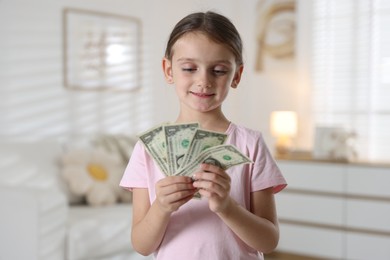 Photo of Little girl holding pocket money at home
