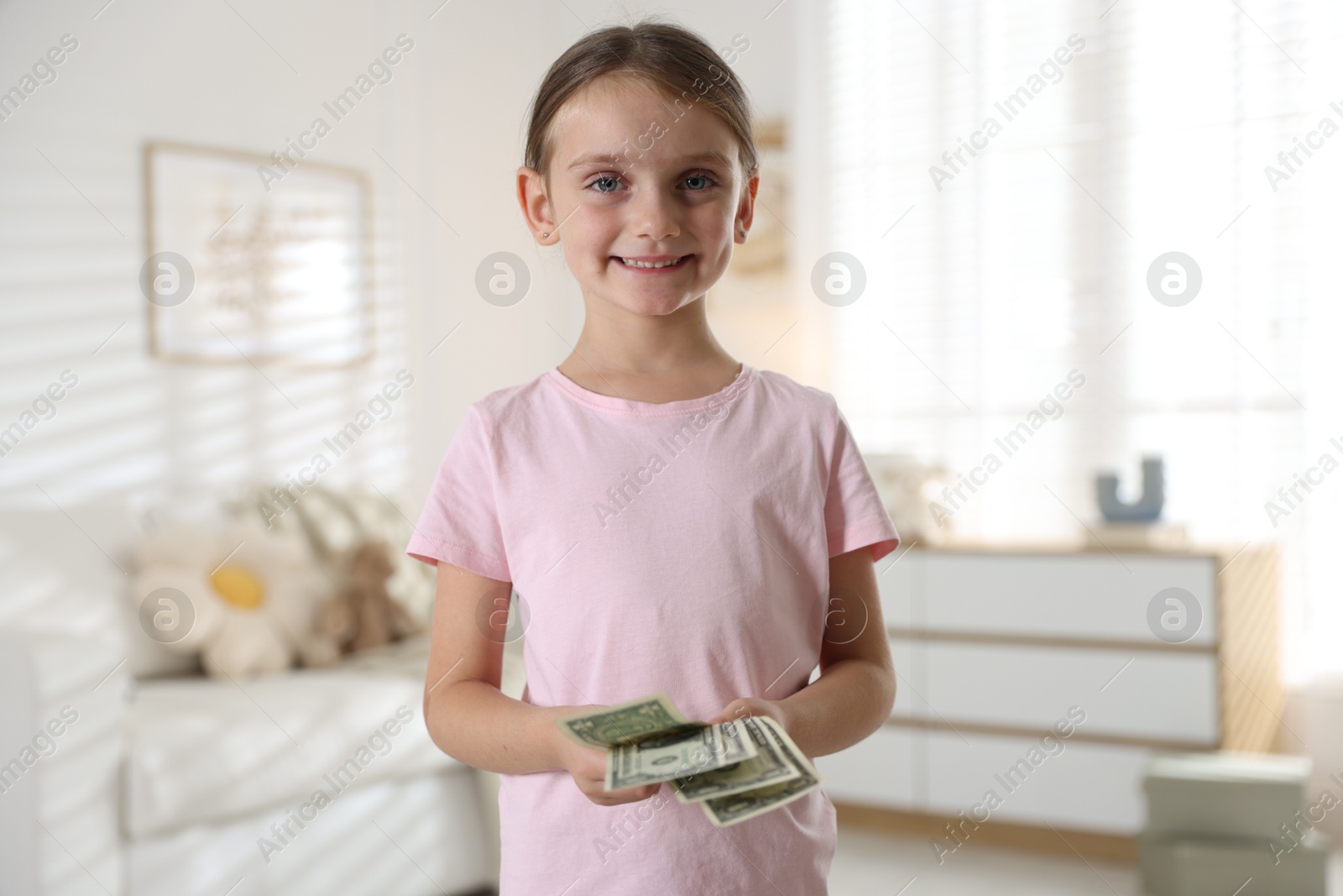 Photo of Little girl holding pocket money at home