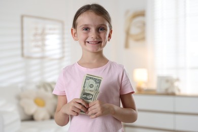 Photo of Little girl holding pocket money at home