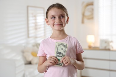 Photo of Little girl holding pocket money at home