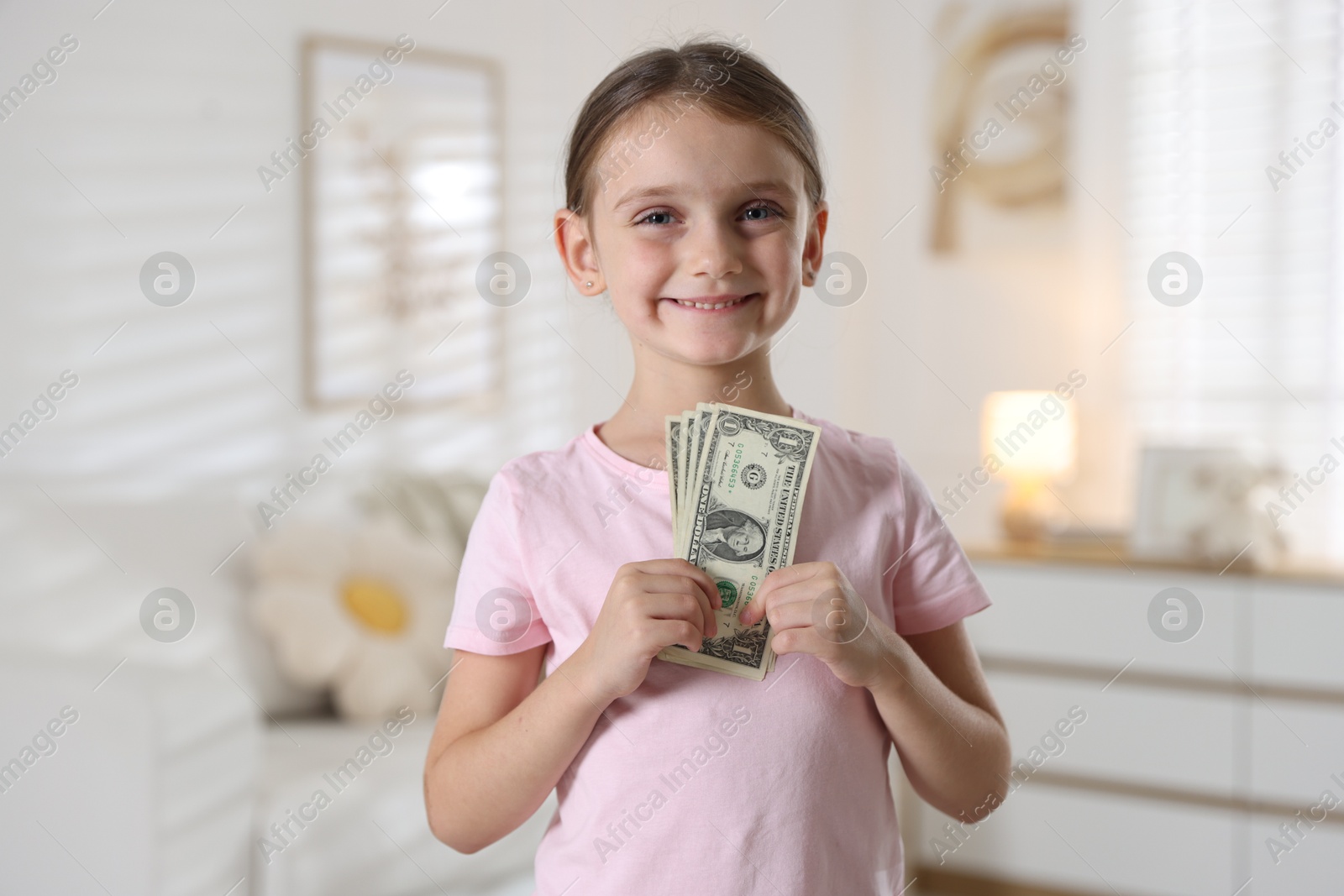 Photo of Little girl holding pocket money at home