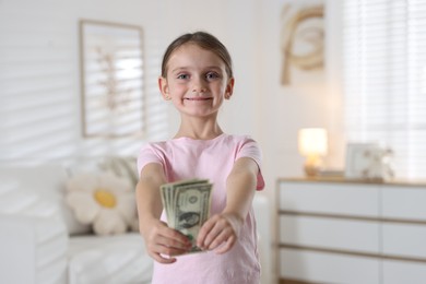 Photo of Little girl holding pocket money at home