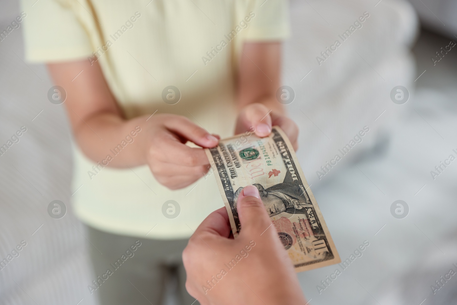 Photo of Mother giving pocket money to her daughter at home, closeup