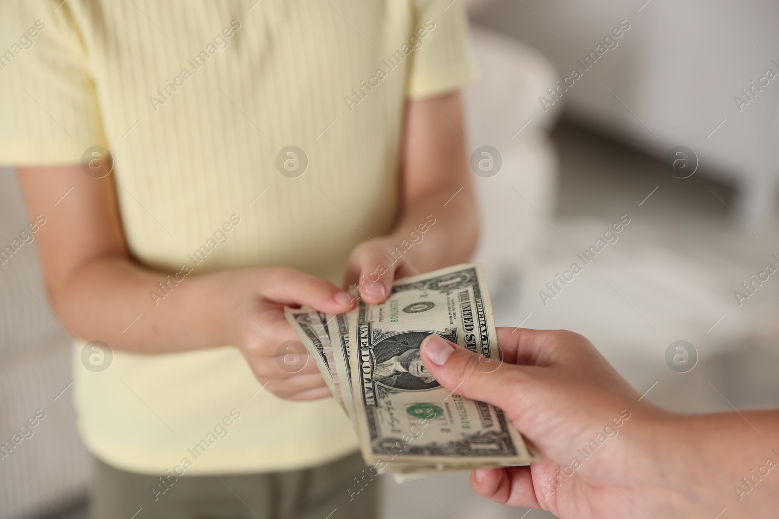 Photo of Mother giving pocket money to her daughter at home, closeup