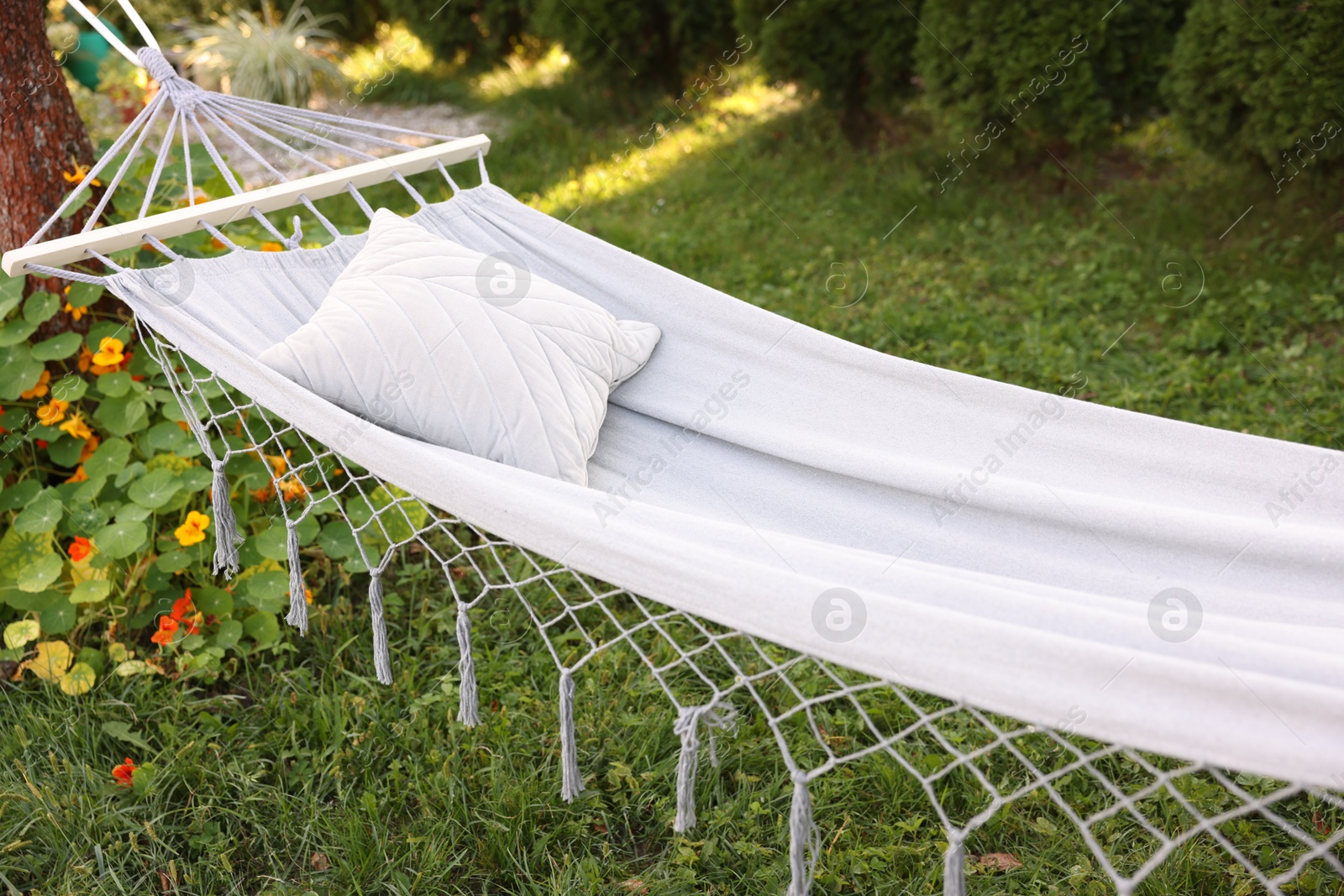Photo of Comfortable white hammock with pillow in garden