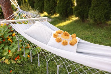 Photo of Comfortable white hammock with pillows in garden
