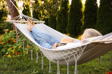 Photo of Senior woman resting in comfortable hammock outdoors