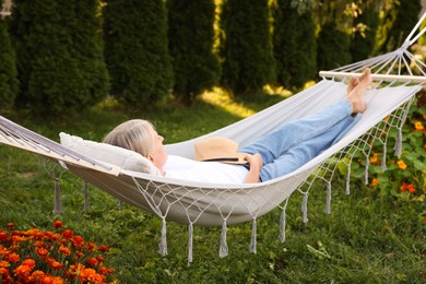 Photo of Senior woman resting in comfortable hammock outdoors