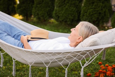 Photo of Senior woman resting in comfortable hammock outdoors