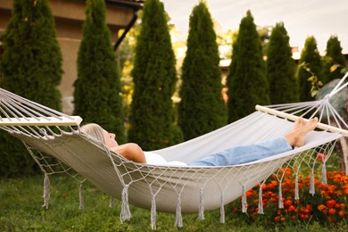Photo of Senior woman resting in comfortable hammock outdoors