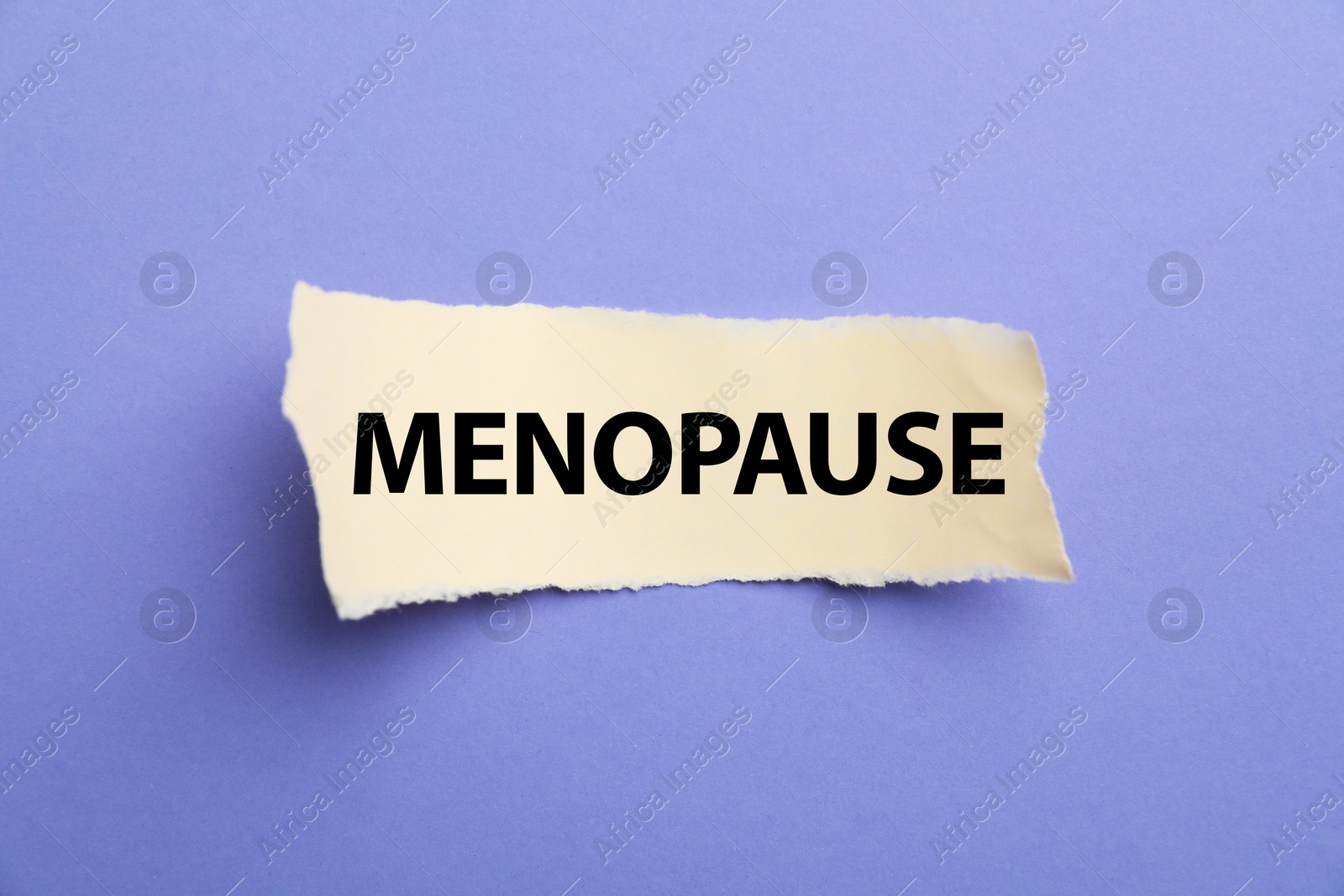 Photo of Paper with word Menopause on violet background, top view