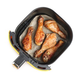 Photo of Air fryer basket with chicken drumsticks isolated on white, top view