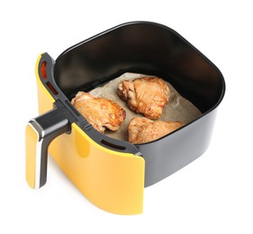 Photo of Air fryer basket with chicken thighs isolated on white