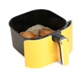 Photo of Air fryer basket with chicken thighs isolated on white