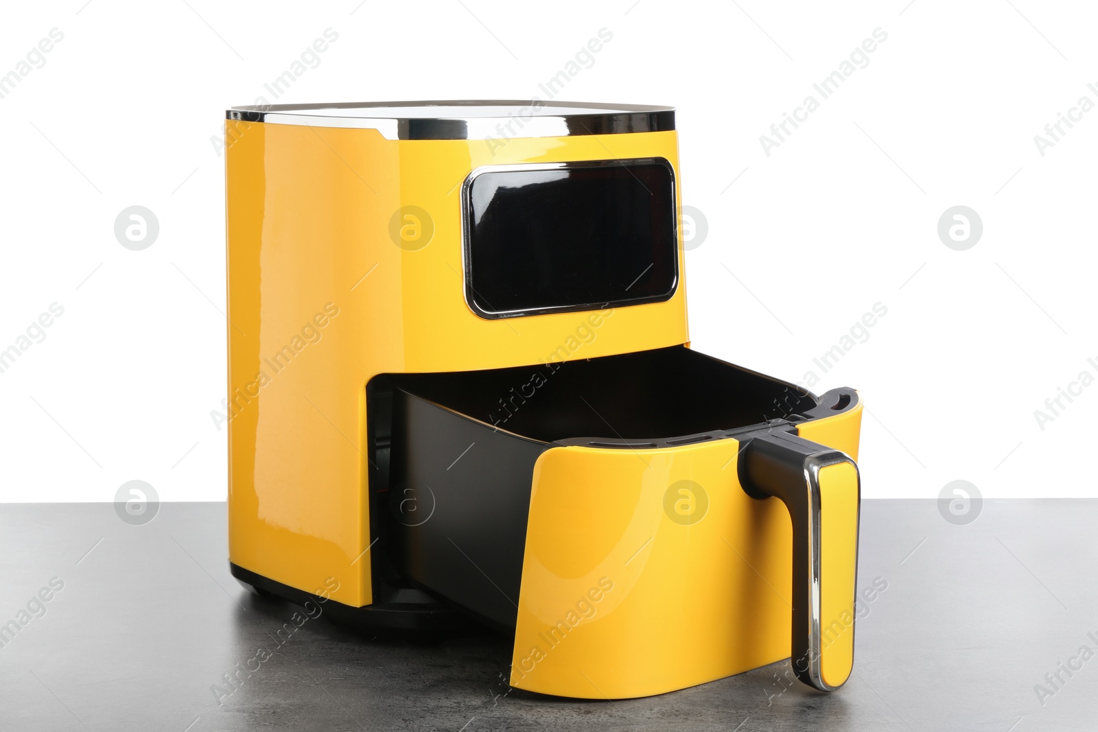 Photo of Modern yellow air fryer on grey table against white background