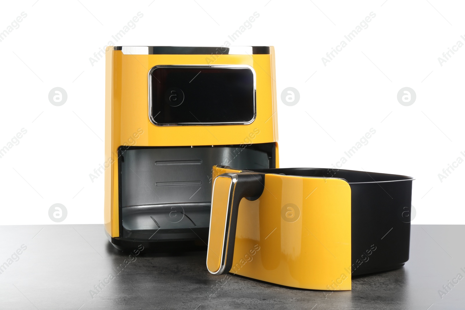 Photo of Modern yellow air fryer on grey table against white background