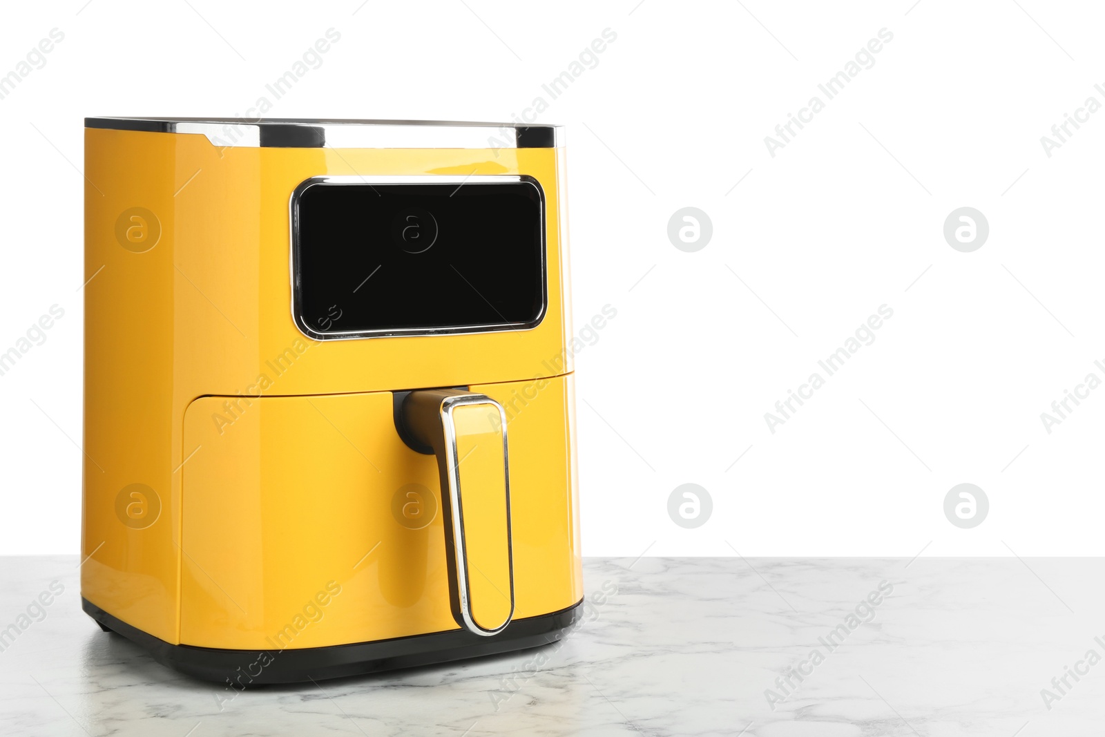 Photo of Modern yellow air fryer on marble table against white background