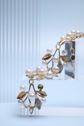 Photo of Stylish presentation of gold bracelet on light blue background, closeup. Space for text