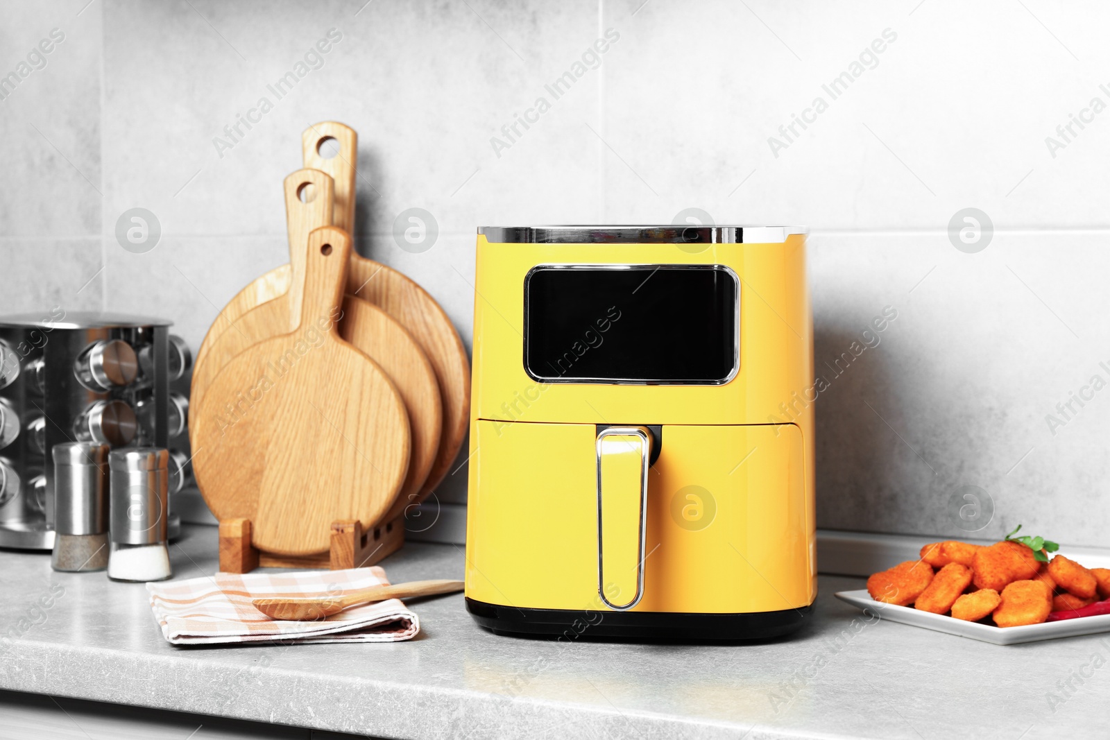 Photo of Air fryer and cooked chicken nuggets on counter in kitchen
