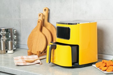 Photo of Air fryer and cooked chicken nuggets on counter in kitchen