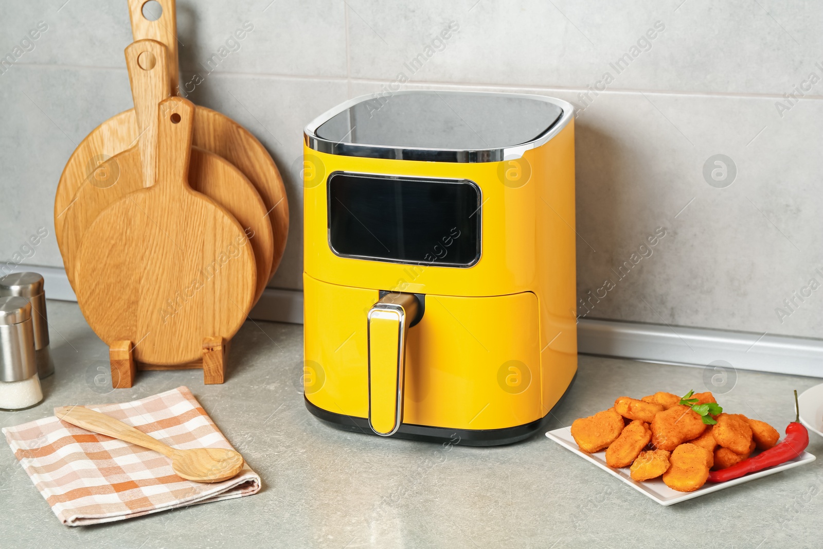 Photo of Air fryer and cooked chicken nuggets on counter in kitchen